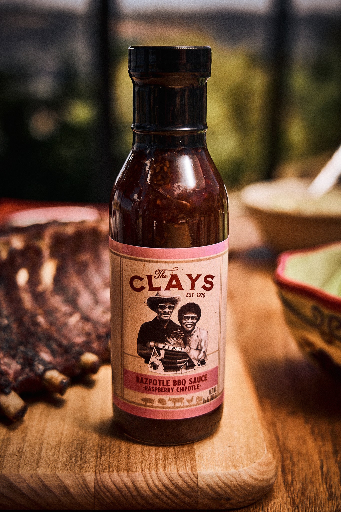 The Clay's Razpotle BBQ Sauce On Table With Food