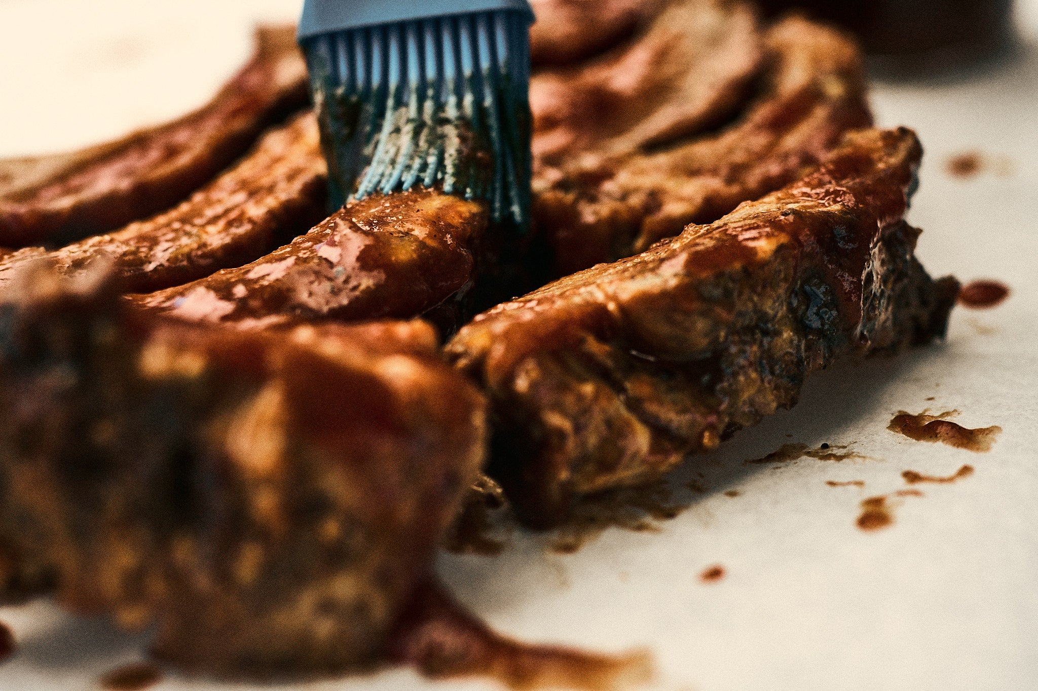 Brushing Clay Family BBQ Sauce On Ribs